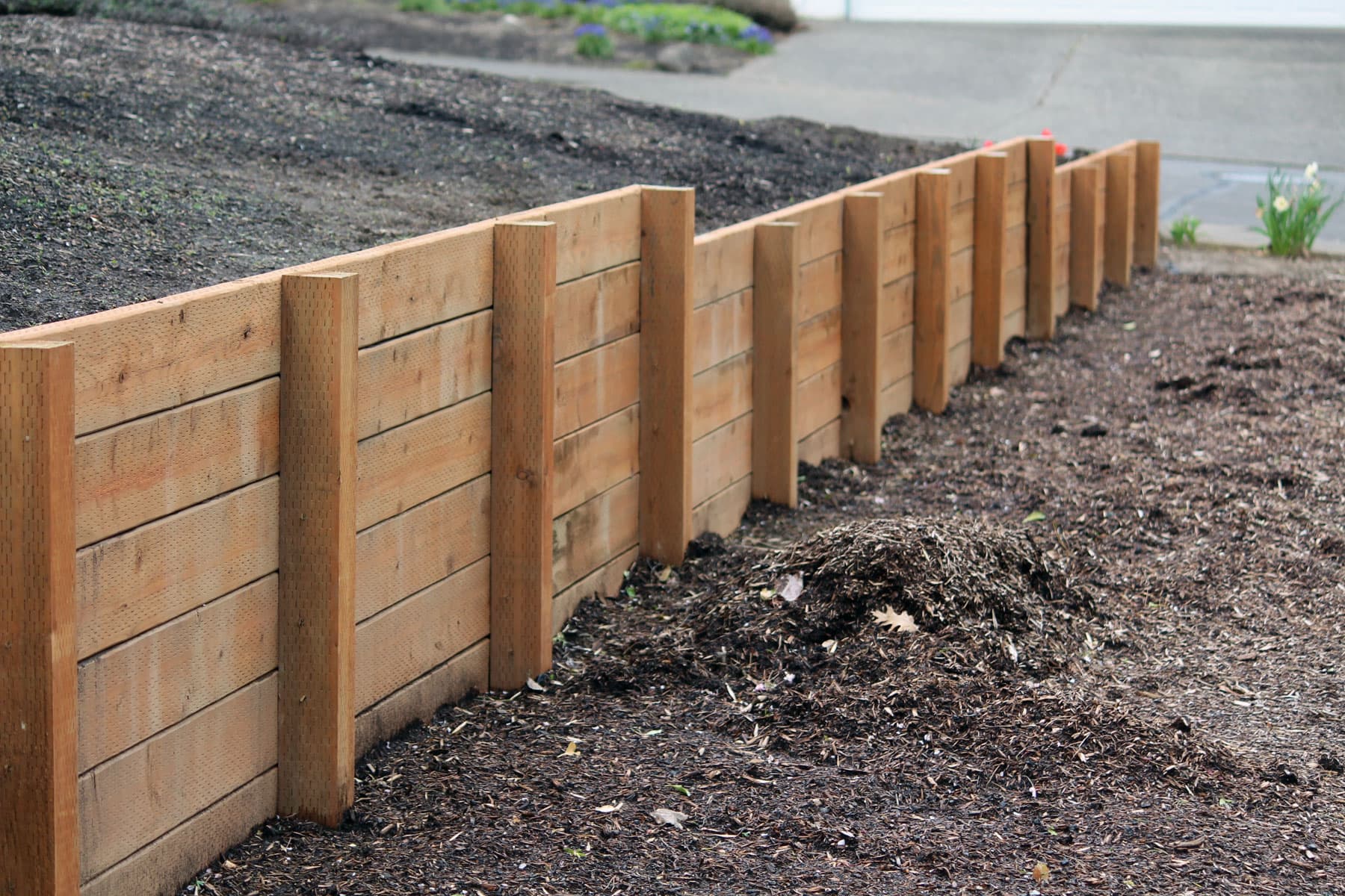 Aging timber retaining wall along a Surrey driveway, the kind of build we typically replace with block or stone